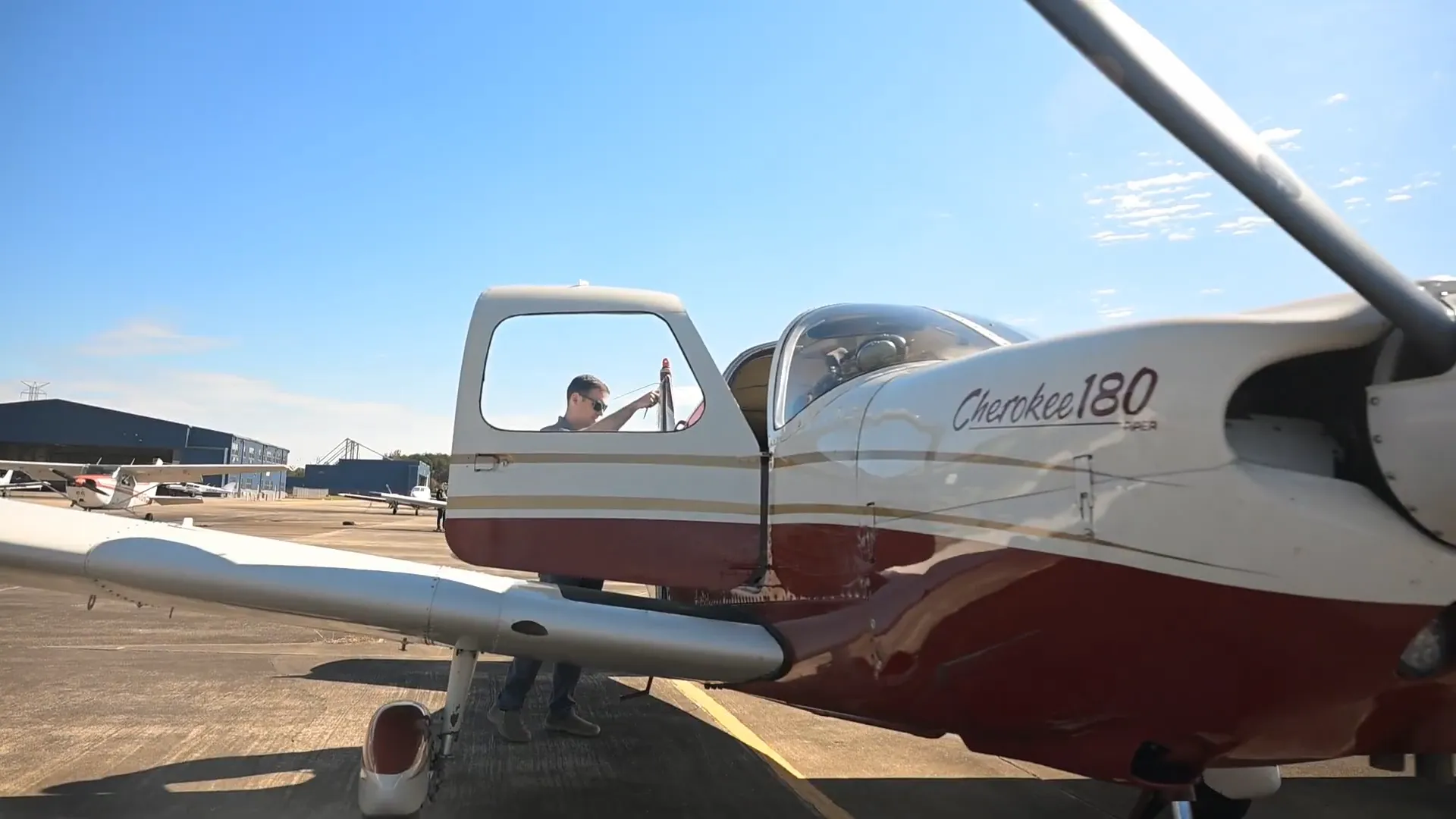 Pilot standing next to the training aircraft with the doors open
