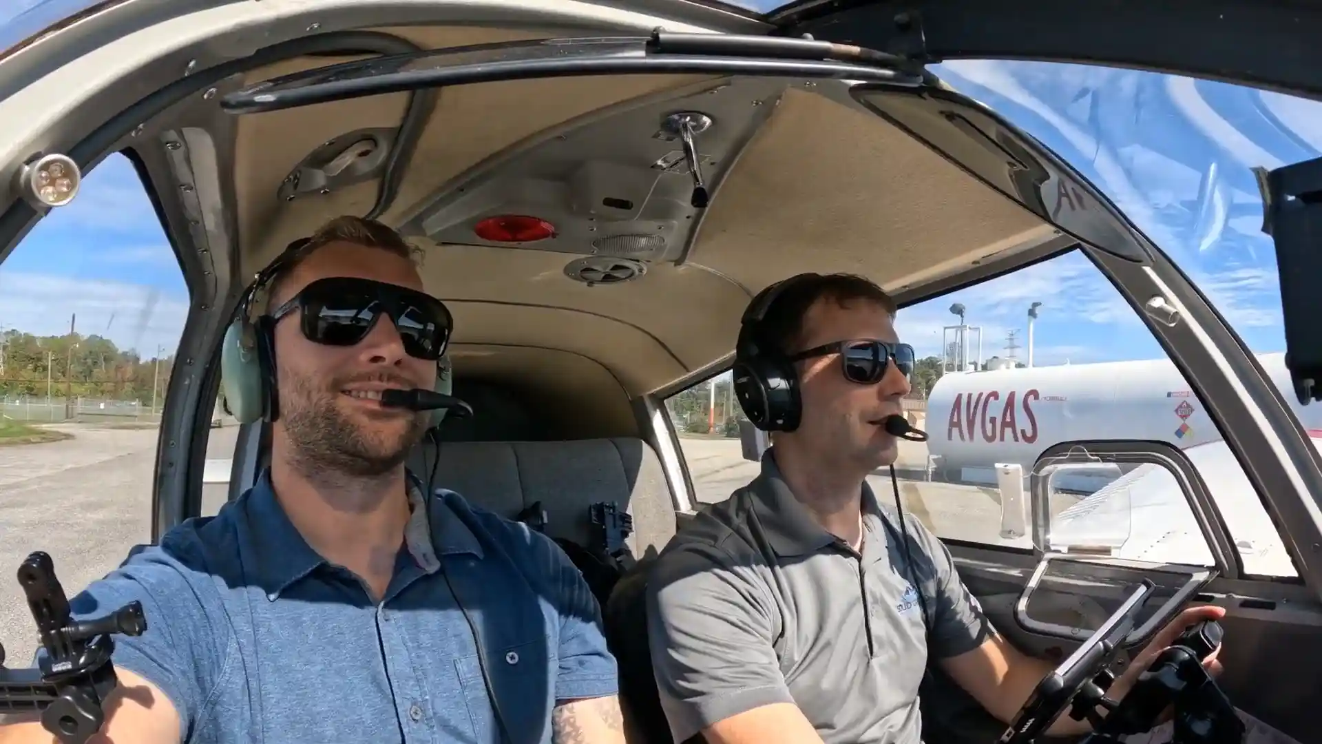 Student pilot and instructor smiling inside the training aircraft