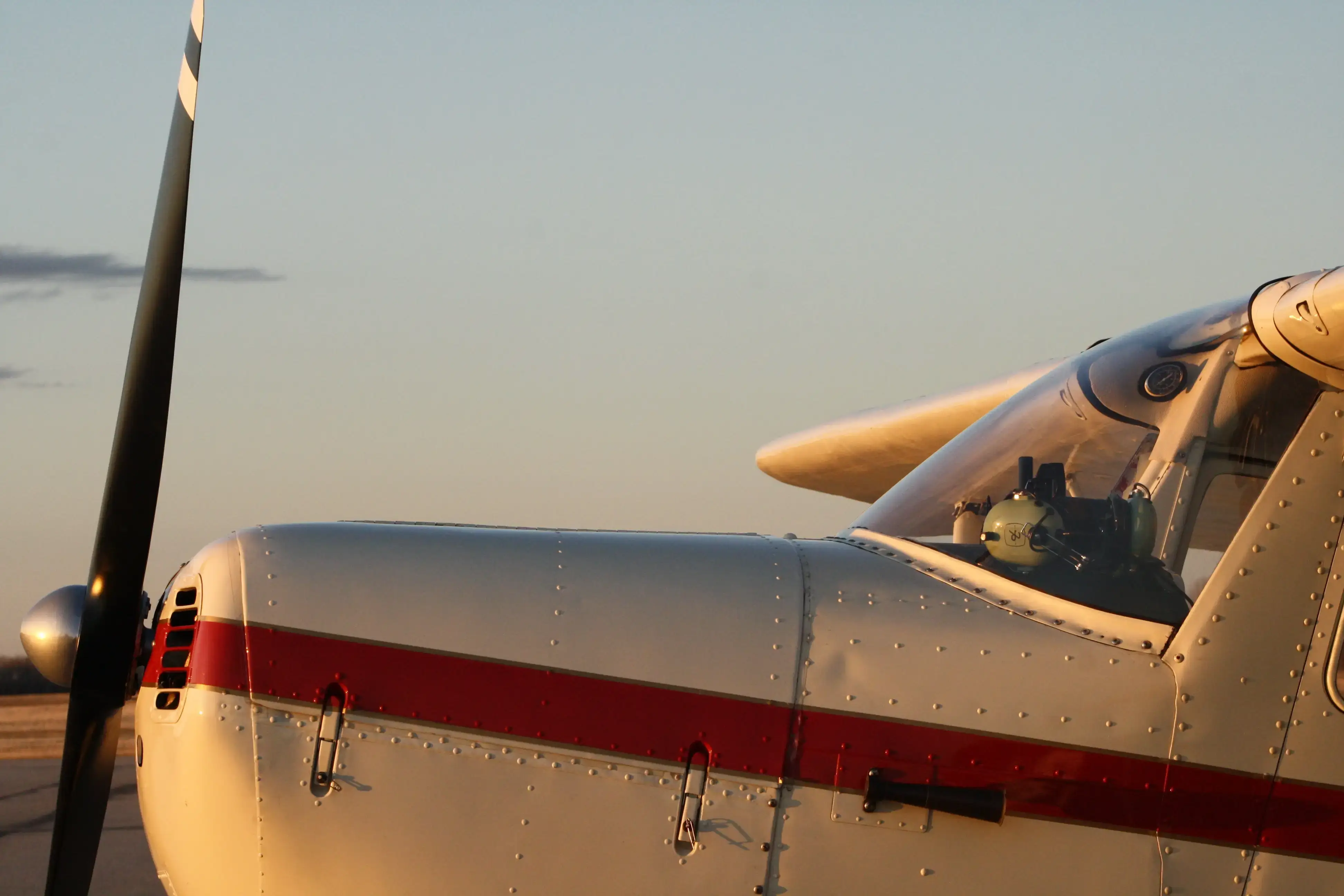 Nose and propeller of a Cessna trainer on the ramp at sunset